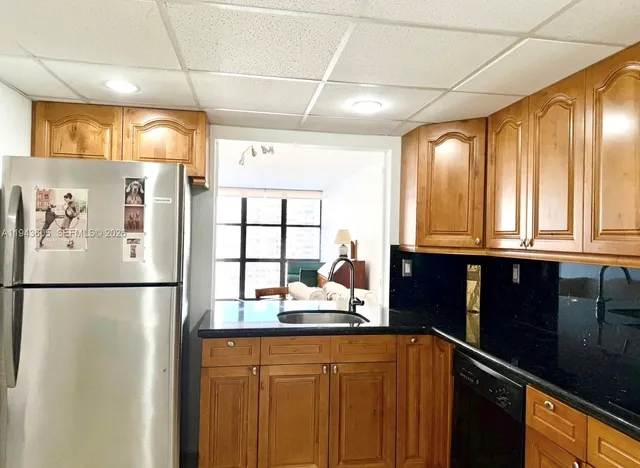 a kitchen with stainless steel appliances granite countertop a refrigerator and a sink