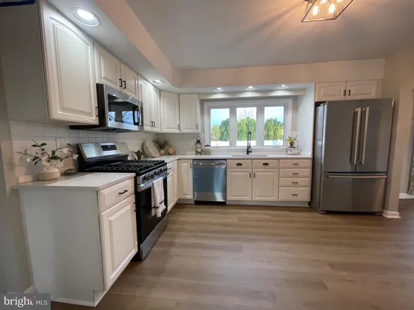 a kitchen with stainless steel appliances a refrigerator sink and microwave