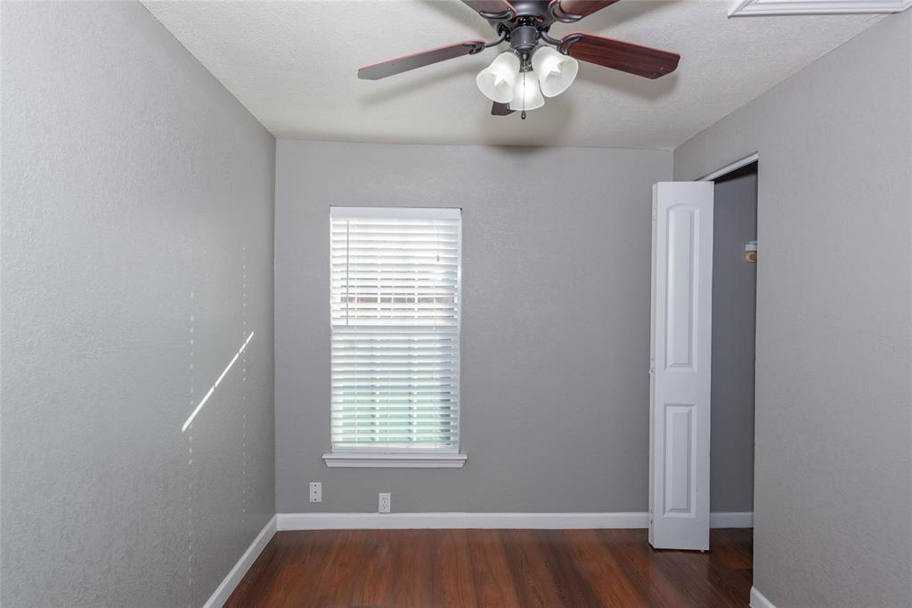 4405 Ray White Road, Unit A Fort Worth, TX 76244 - Photo 16 of 20 an empty room with wooden floor chandelier fan and windows
