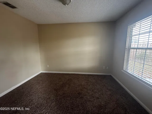 a view of an empty room with a fireplace and a window