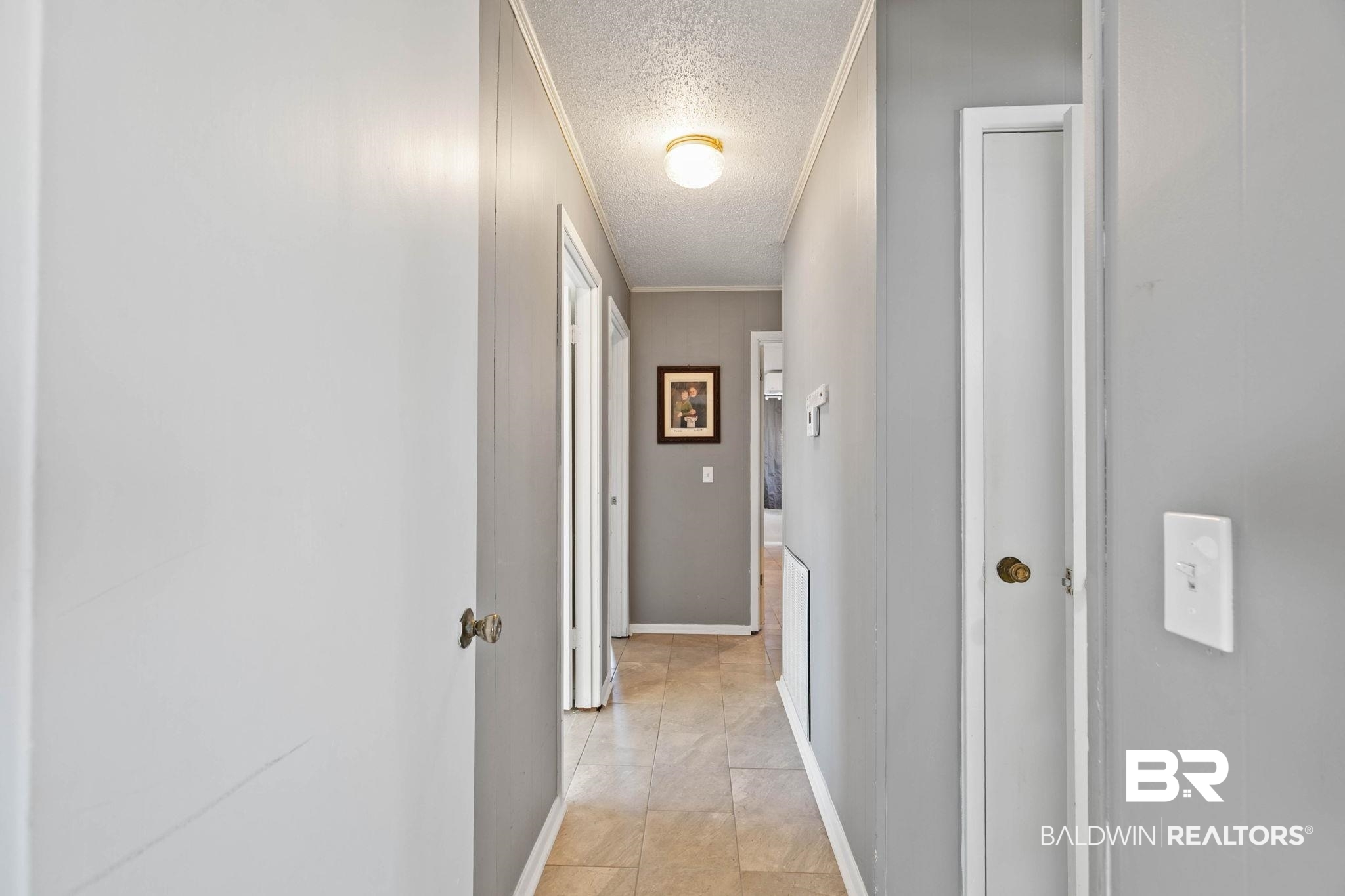 21267 Loop Road Andalusia, AL 36421 - Photo 39 of 72 Corridor with a textured ceiling and light tile patterned floors