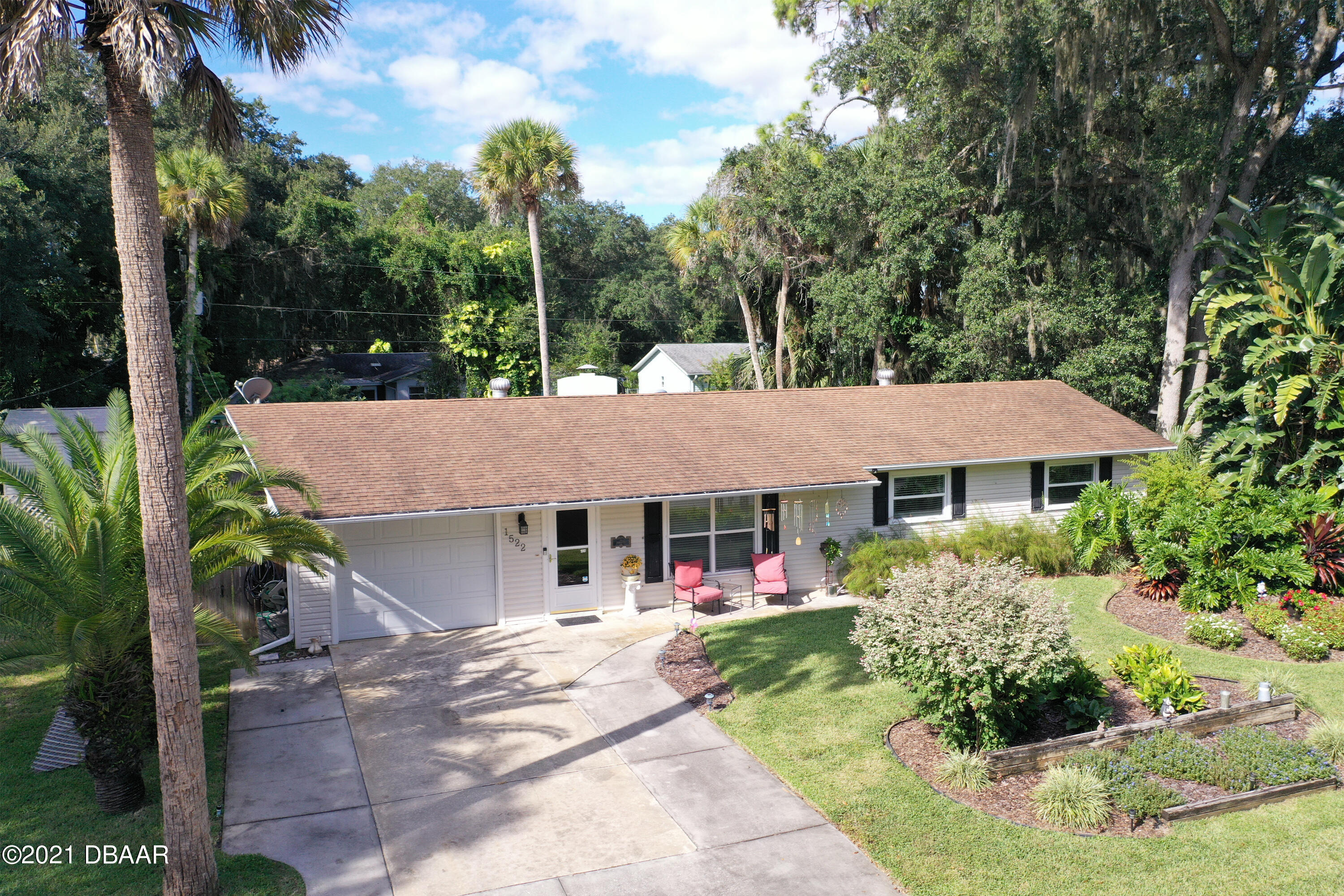 1522 Pine Tree Drive Edgewater, FL 32132 - Photo 1 of 26 a view of a white house with large trees and plants