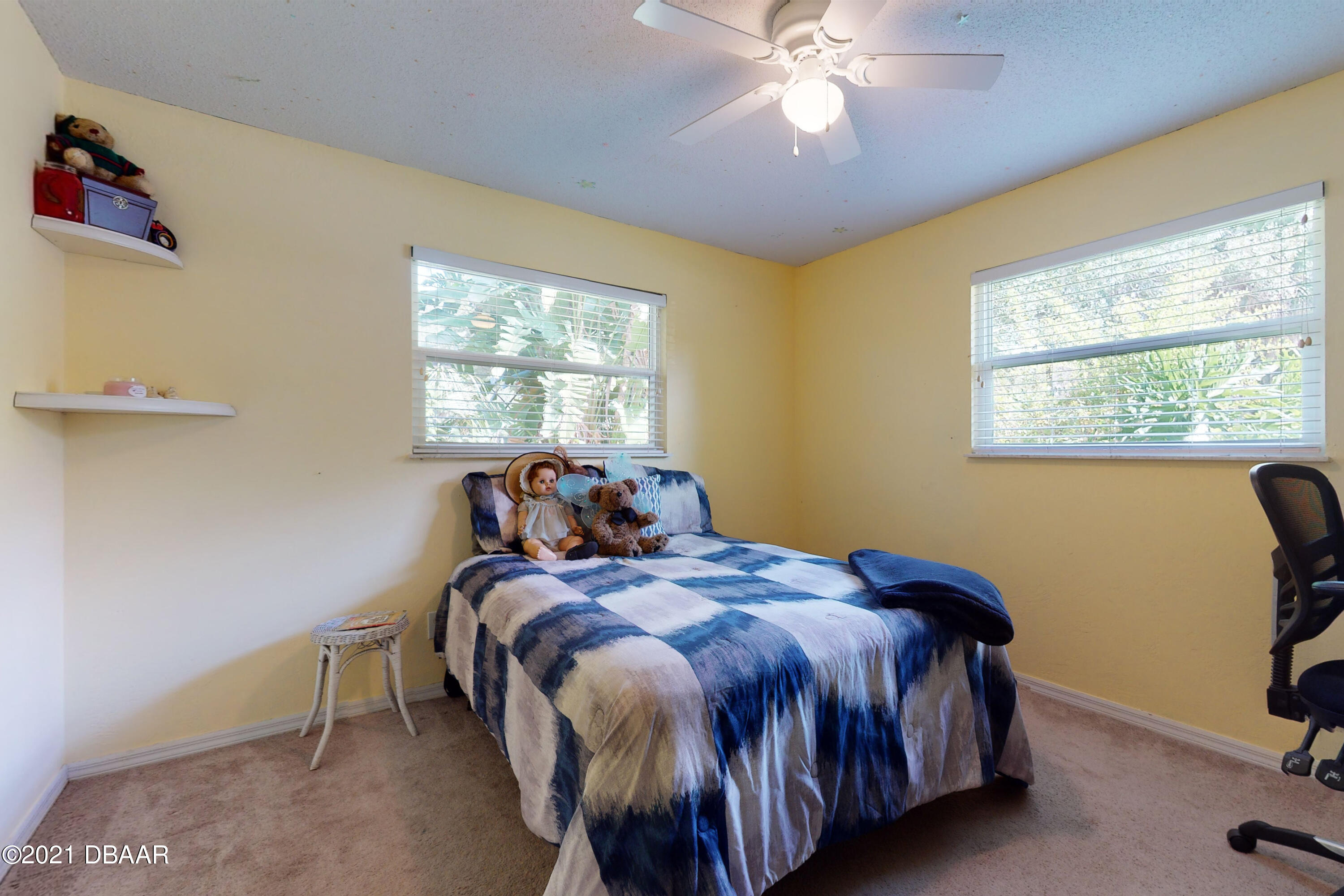 1522 Pine Tree Drive Edgewater, FL 32132 - Photo 11 of 26 a bed sitting in a bedroom next to a window