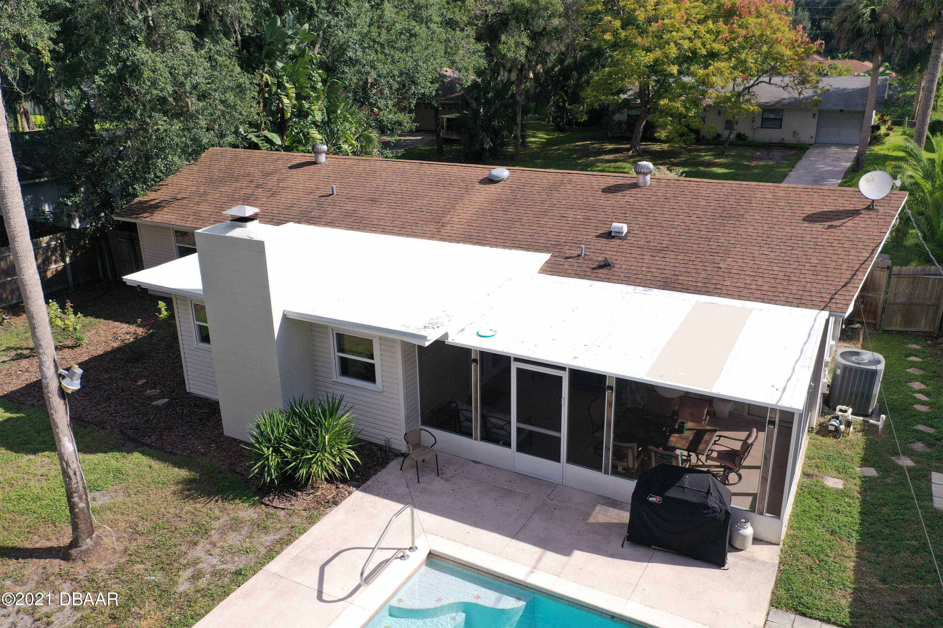 1522 Pine Tree Drive Edgewater, FL 32132 - Photo 19 of 26 a view of a patio with table and chairs with wooden fence and plants