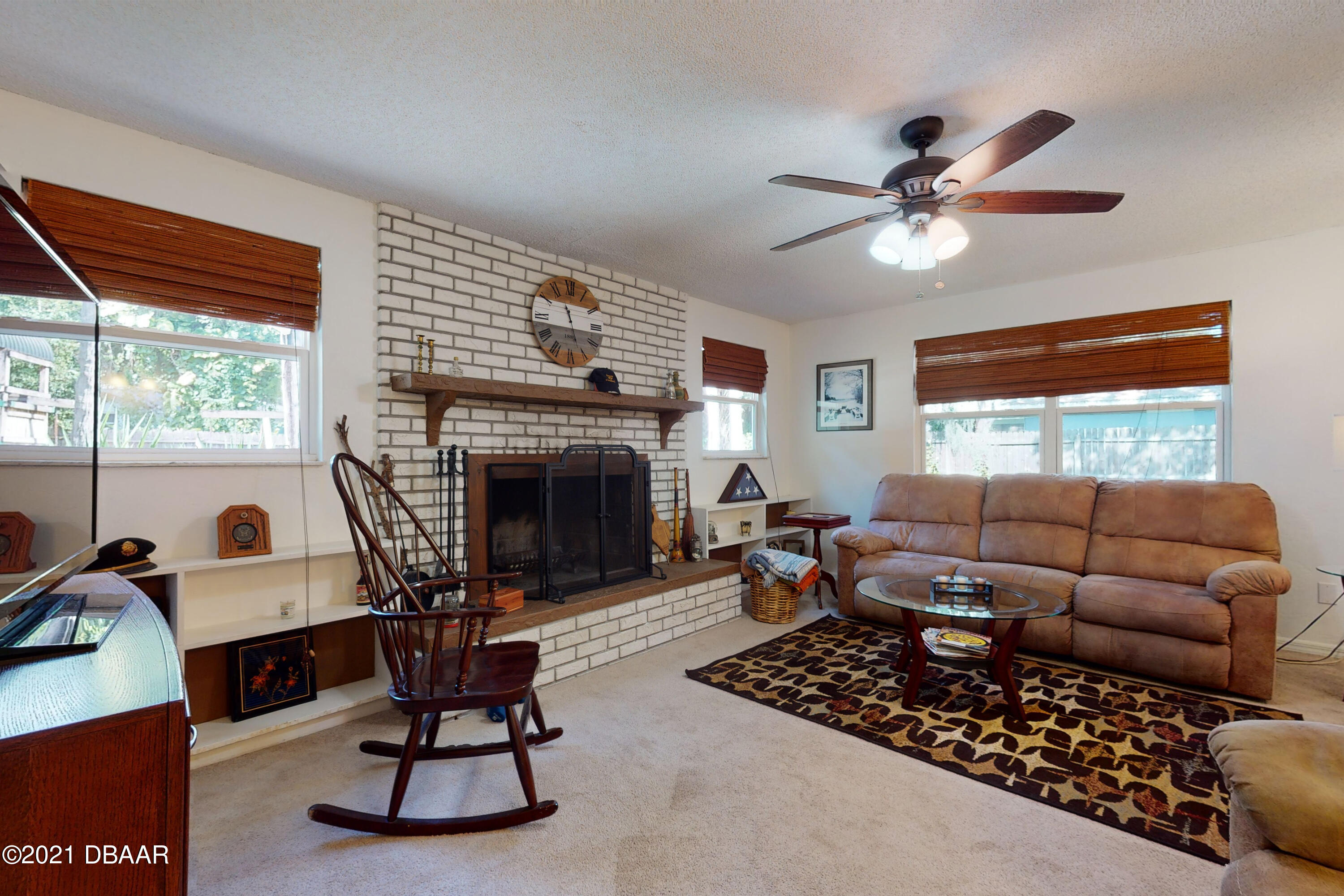 1522 Pine Tree Drive Edgewater, FL 32132 - Photo 7 of 26 a living room with furniture a fireplace and a large window