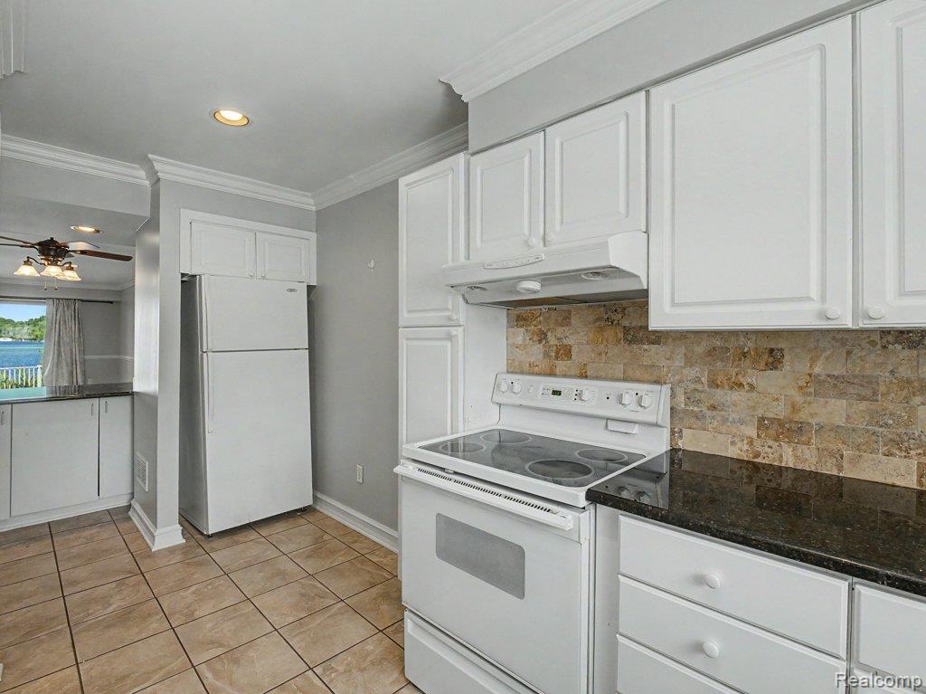 1974 Klingensmith Road, Unit 4 Bloomfield Hills, MI 48302 - Photo 9 of 35 Kitchen featuring white cabinetry, dark countertops, a stone tile backsplash, and tile flooring