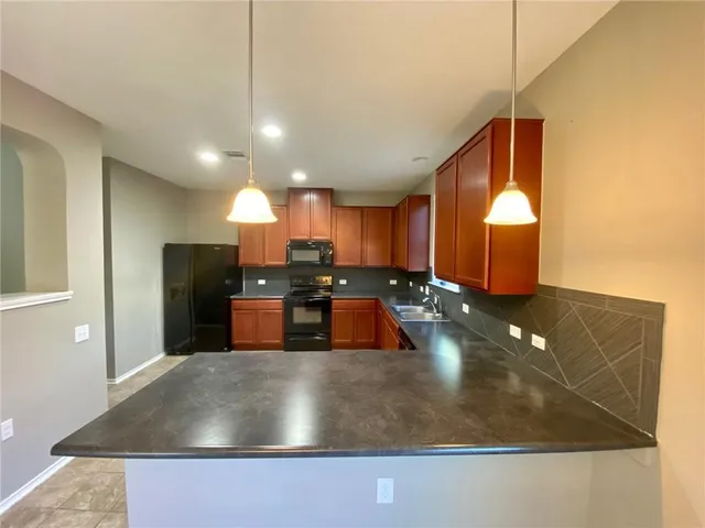 a kitchen with kitchen island a sink stainless steel appliances and a counter top