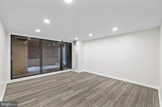 an empty room with wooden floor and white walls