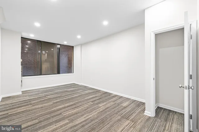 a view of an empty room with wooden floor