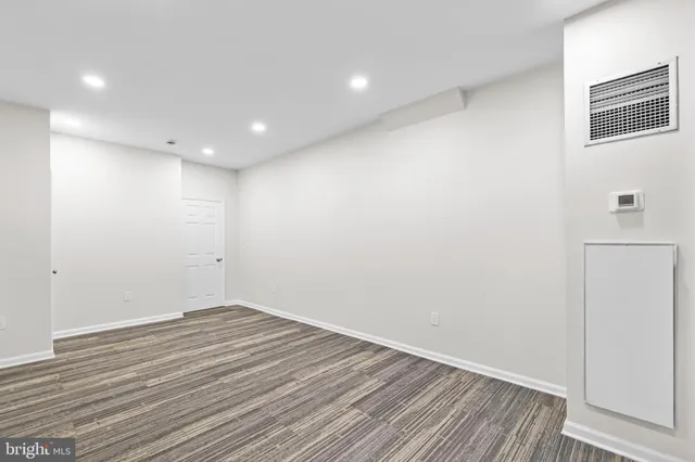 a spacious bedroom with a bed and a flat screen tv