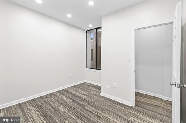 an empty room with wooden floor and closet