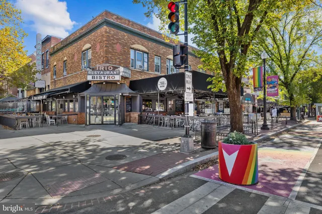 a view of a cafe with a table and chairs under an umbrella