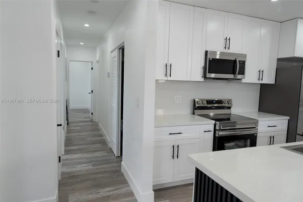 a kitchen with white cabinets and stainless steel appliances