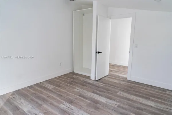 a view of an empty room with wooden floor