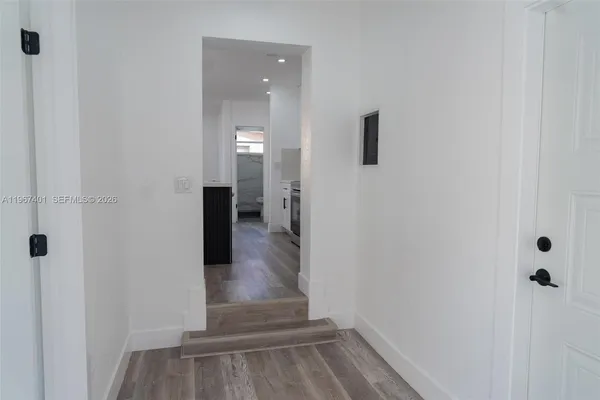 a view of a hallway with wooden floor and staircase