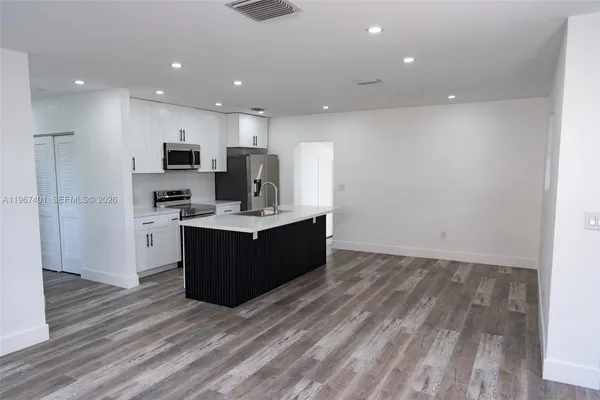 a living room with stainless steel appliances kitchen island wooden floors and view living room