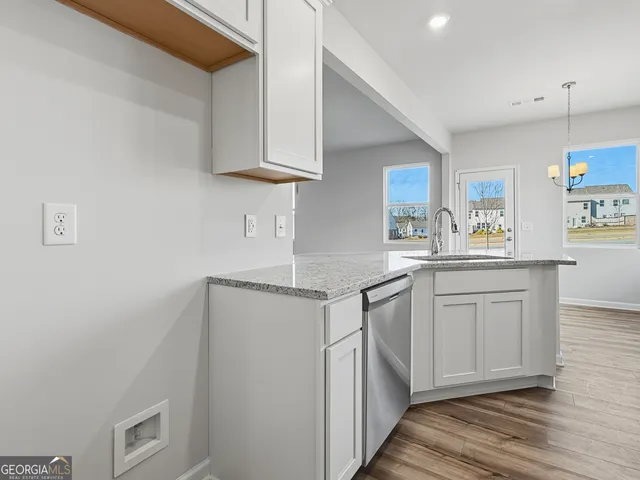 a kitchen with stainless steel appliances granite countertop a sink stove and cabinets