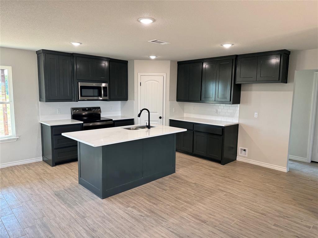 760 Smith Road Springtown, TX 76082 - Photo 3 of 9 a kitchen with a sink and a microwave