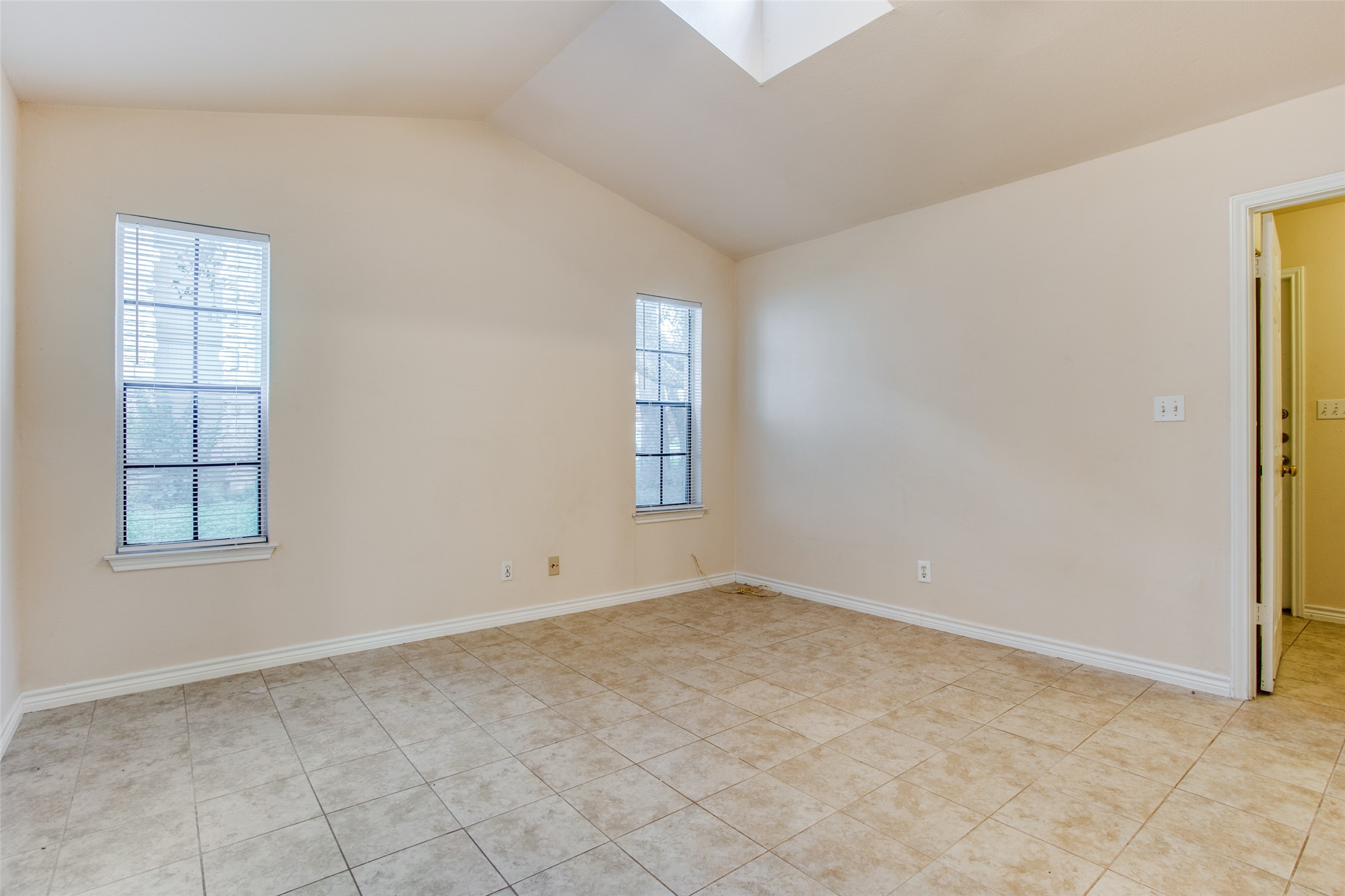 8811 Clearbrook Trail Austin, TX 78729 - Photo 29 of 38 rt B - A skylight and large windows provide abundant natural light to this tile-floored living space.