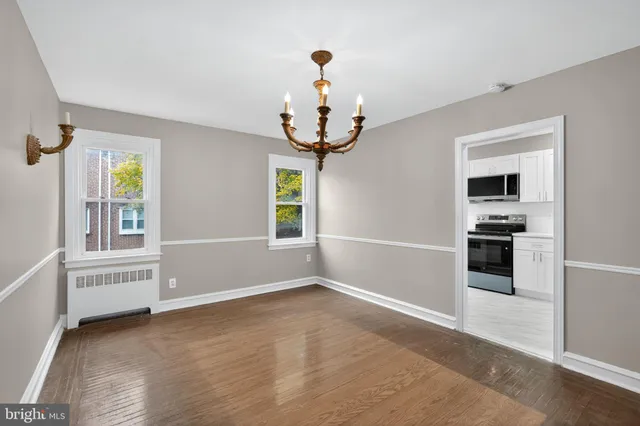 a view of empty room with wooden floor and windows