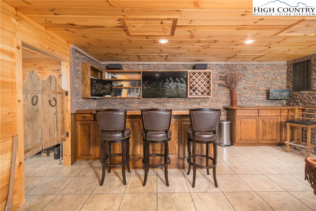 175 Woods Road Boone, NC 28607 - Photo 37 of 50 a kitchen with stainless steel appliances kitchen island granite countertop a table chairs and a refrigerator