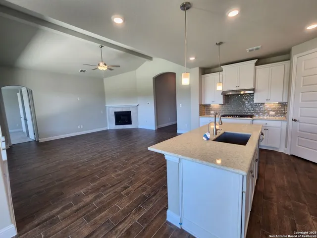 a kitchen with stainless steel appliances granite countertop a sink a stove and a refrigerator