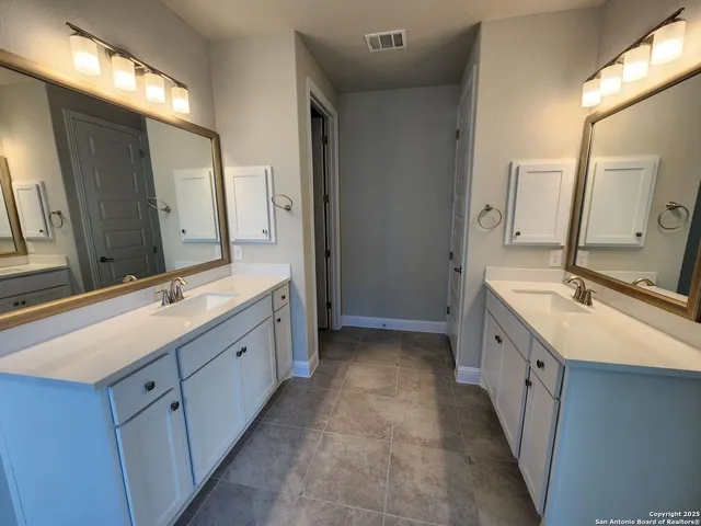 a spacious bathroom with a double vanity sink and mirror