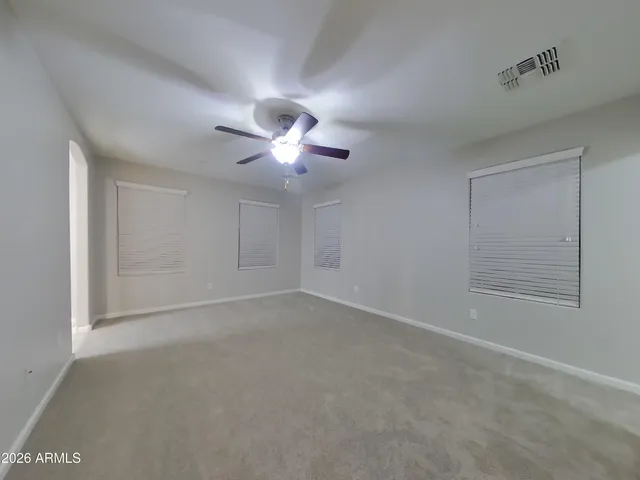 a view of an empty room with a chandelier fan