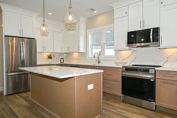 a kitchen with stainless steel appliances granite countertop a sink stove and refrigerator