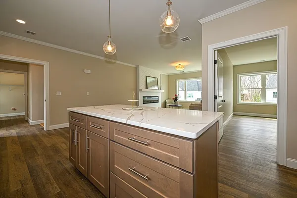 a kitchen with kitchen island a sink dishwasher a dining table and chairs with wooden floor