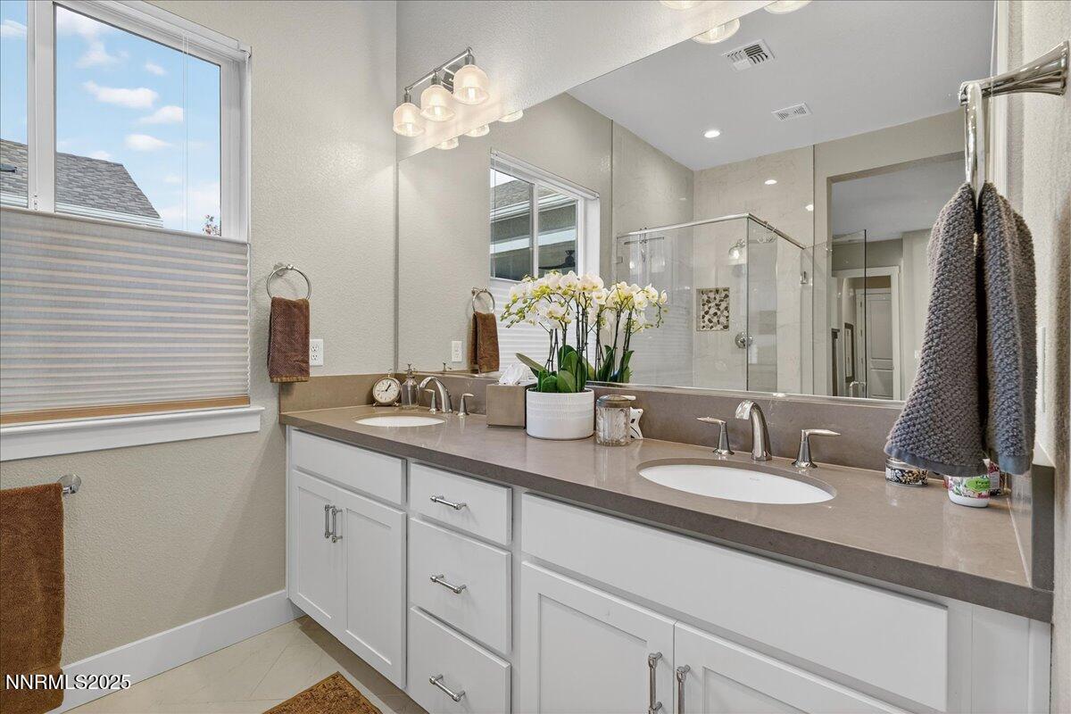 2160 Woodhouse Drive Reno, NV 89521 - Photo 16 of 38 a bathroom with double vanity sinks a vanity a lamp and a mirror