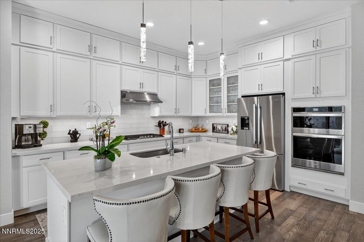 2160 Woodhouse Drive Reno, NV 89521 - Photo 7 of 38 a kitchen with stainless steel appliances a white table chairs refrigerator and cabinets