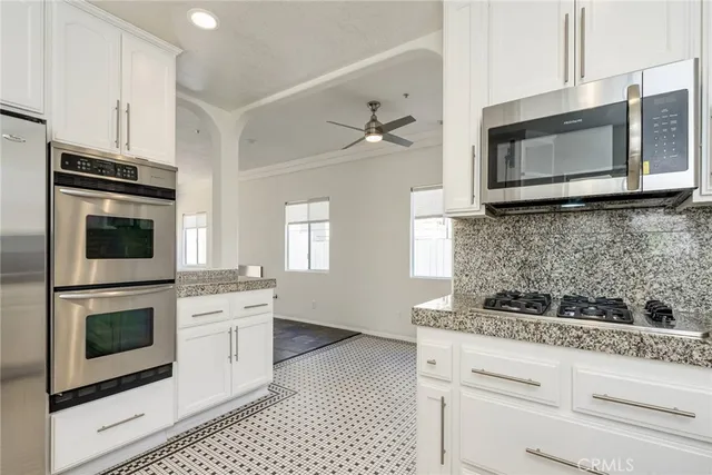 a kitchen with stainless steel appliances granite countertop a stove microwave and sink