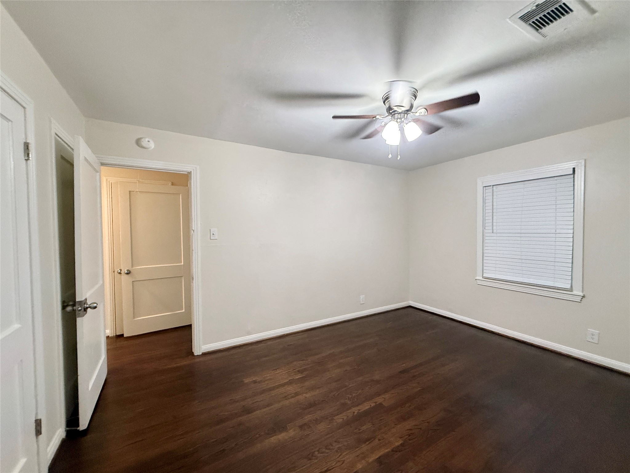 1232 San Felipe Street Angleton, TX 77515 - Photo 9 of 16 an empty room with wooden floor chandelier fan and windows