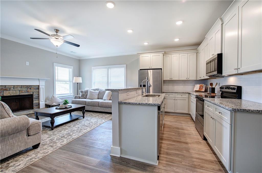 200 Daisy Court Cartersville, GA 30121 - Photo 26 of 73 a kitchen with sink stove and white cabinets with wooden floor