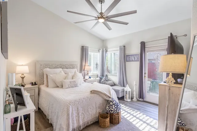 a bedroom with a bed a couch and a chandelier