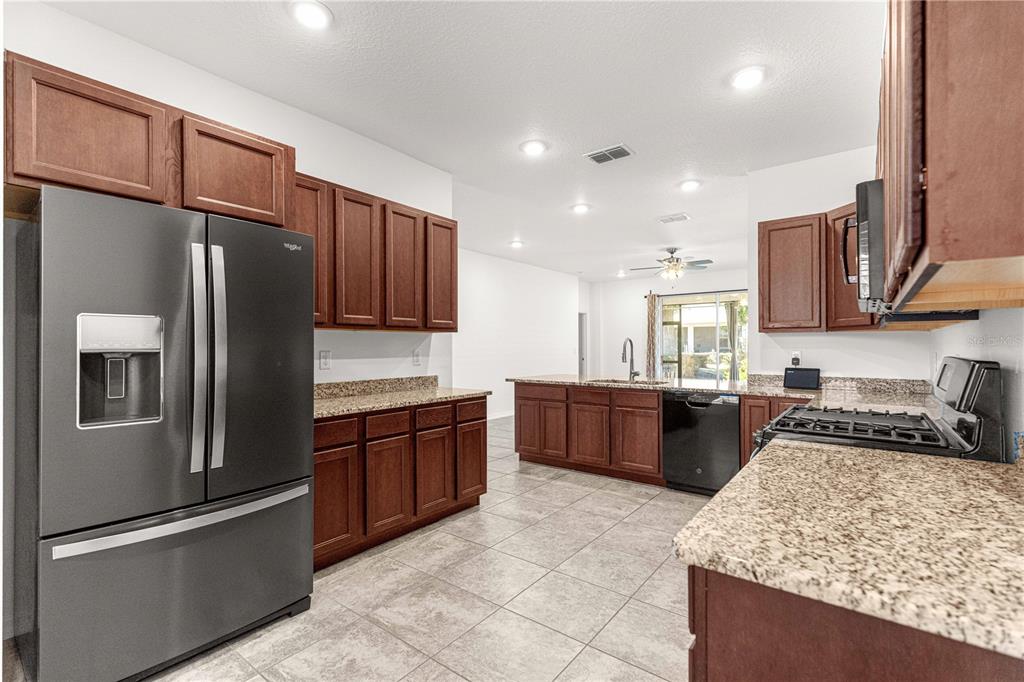 8546 Southwest 79th Avenue Ocala, FL 34476 - Photo 18 of 42 a kitchen with stainless steel appliances granite countertop a refrigerator stove top oven and sink