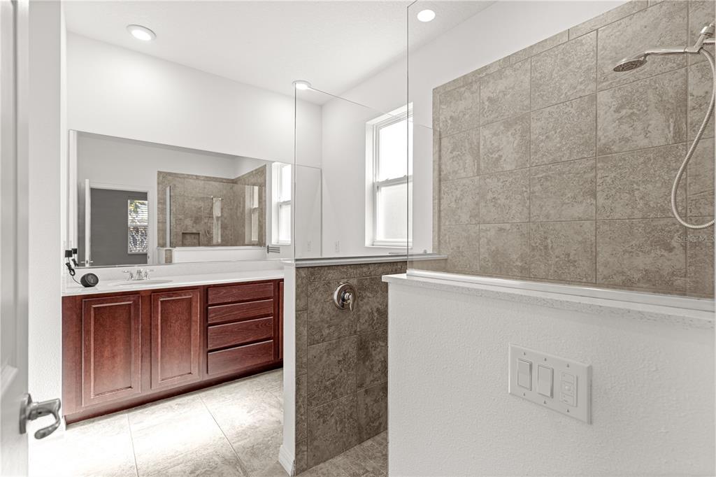 8546 Southwest 79th Avenue Ocala, FL 34476 - Photo 30 of 42 a bathroom with a double vanity sink a large mirror and a bathtub