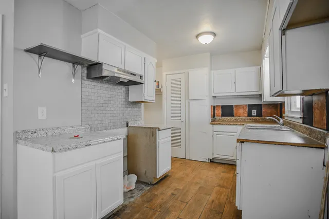 a kitchen with stainless steel appliances granite countertop a sink stove refrigerator and cabinets
