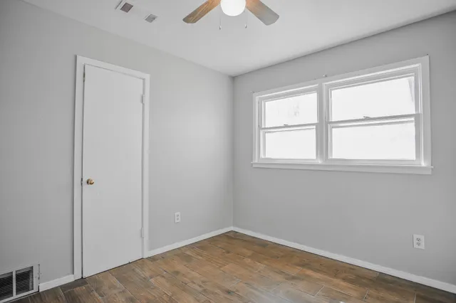 an empty room with a chandelier fan
