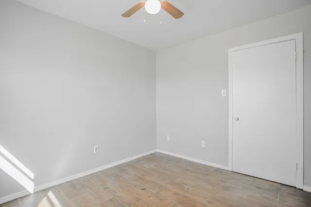 an empty room with a window and a fan