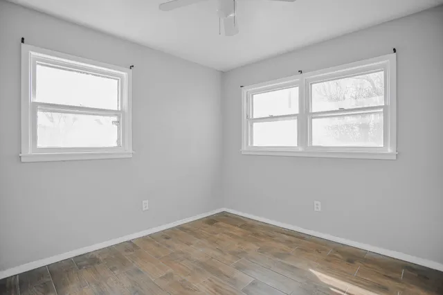 a view of empty room with wooden floor