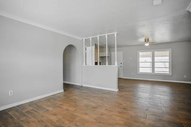 an empty room with wooden floor and windows