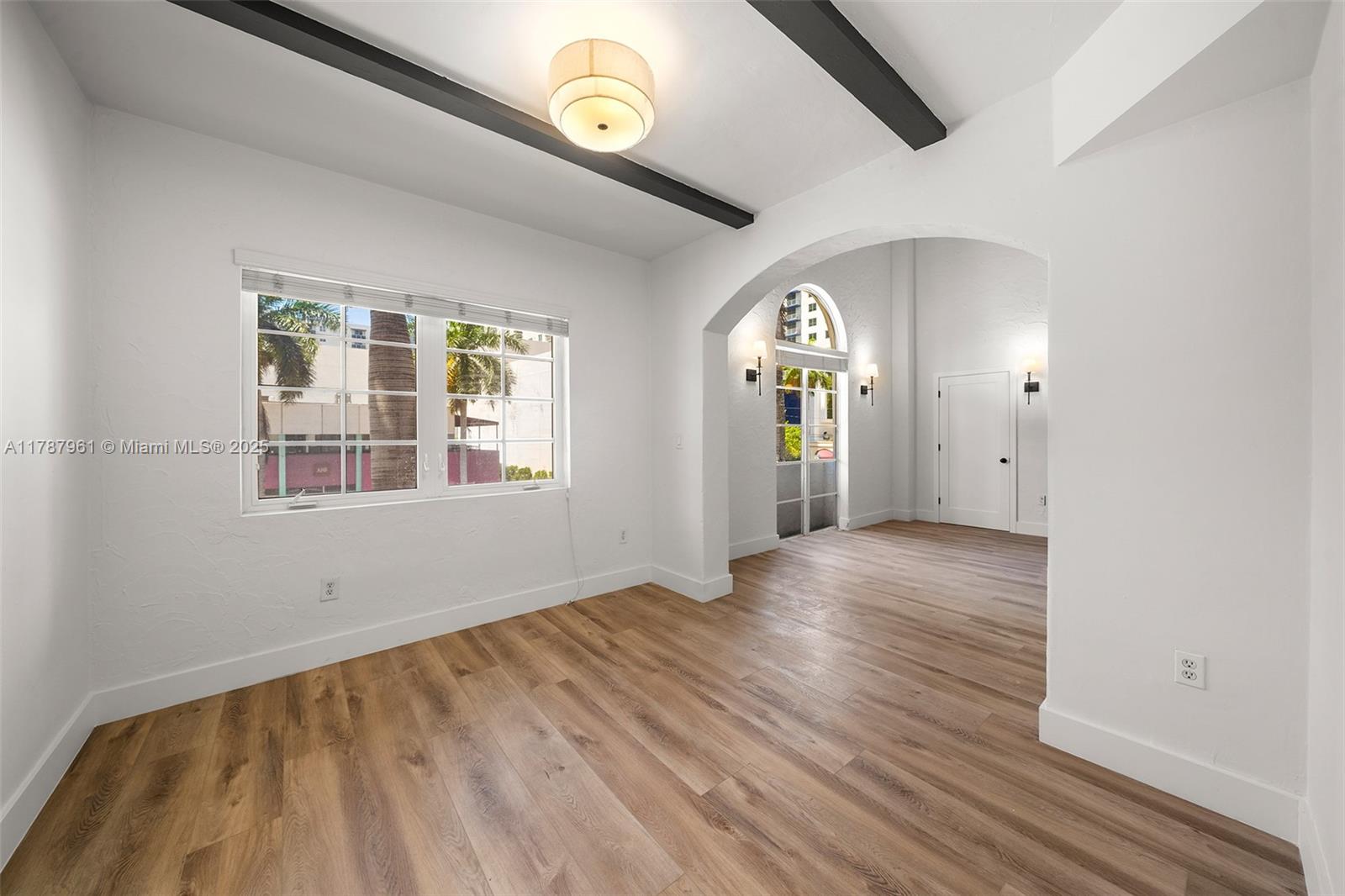 2411 Biscayne Boulevard, Unit 2 Miami, FL 33137 - Photo 16 of 25 an empty room with wooden floor and windows