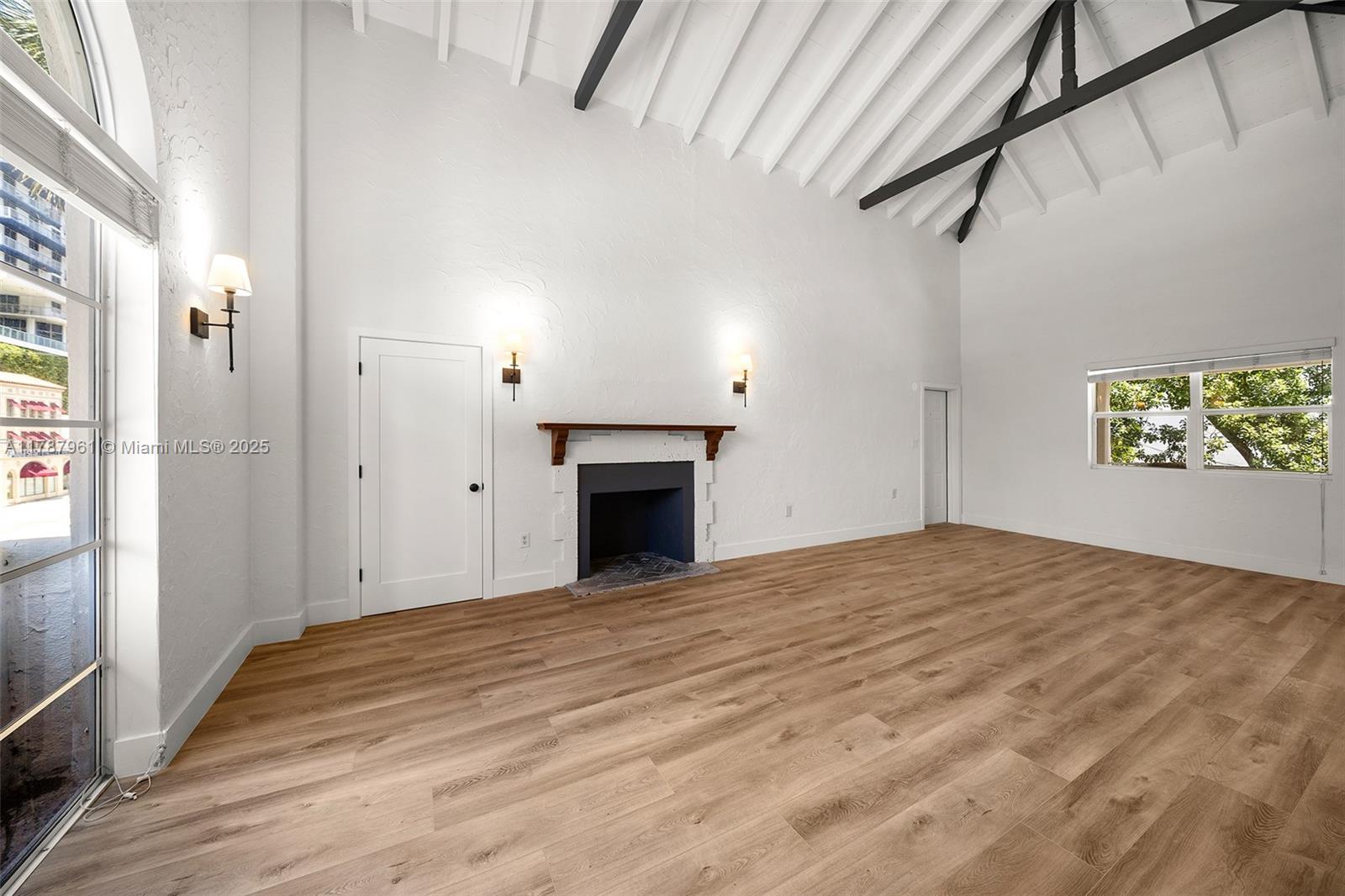 2411 Biscayne Boulevard, Unit 2 Miami, FL 33137 - Photo 3 of 25 a view of an empty room with a fireplace and a window