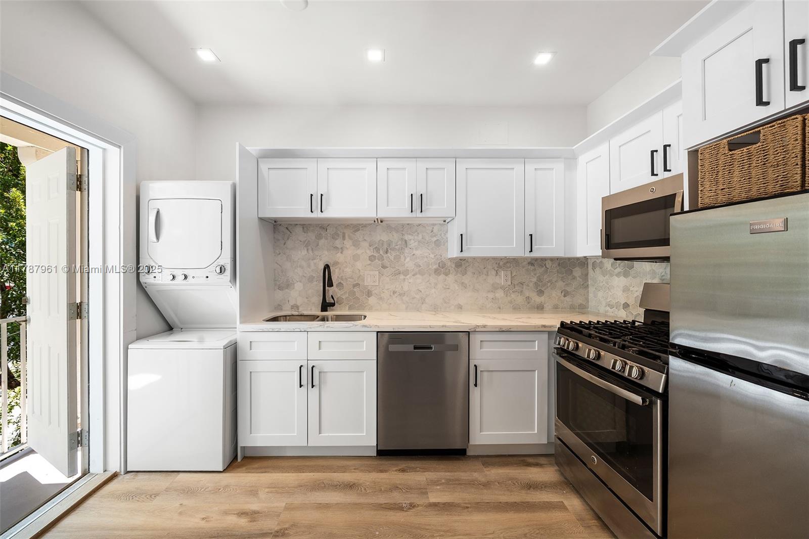 2411 Biscayne Boulevard, Unit 2 Miami, FL 33137 - Photo 4 of 25 a kitchen with stainless steel appliances granite countertop a stove a sink and a microwave