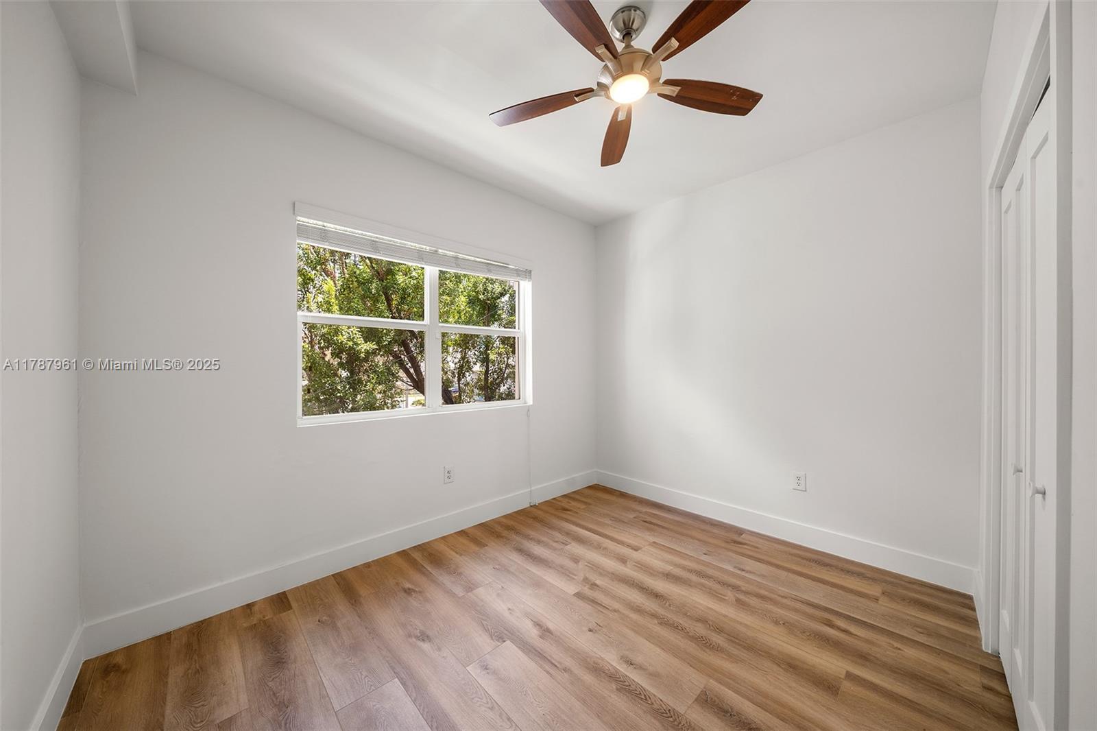 2411 Biscayne Boulevard, Unit 2 Miami, FL 33137 - Photo 10 of 25 an empty room with a window and a ceiling fan