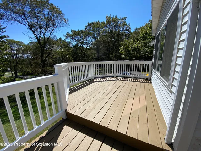 a view of balcony with wooden floor and fence