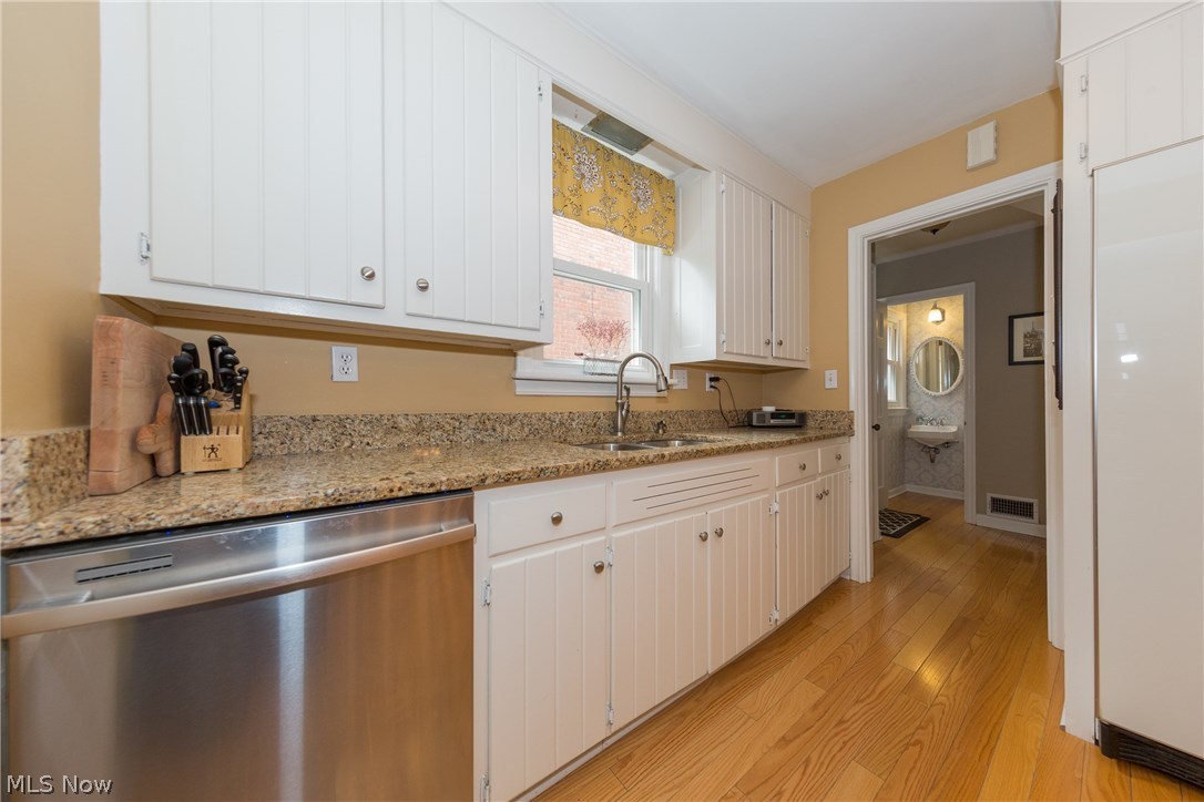 2465 Traymore Road Cleveland, OH 44118 - Photo 7 of 34 The remodeled Kitchen with granite counters and white wood cabinets, complimented by gleaming wood floors