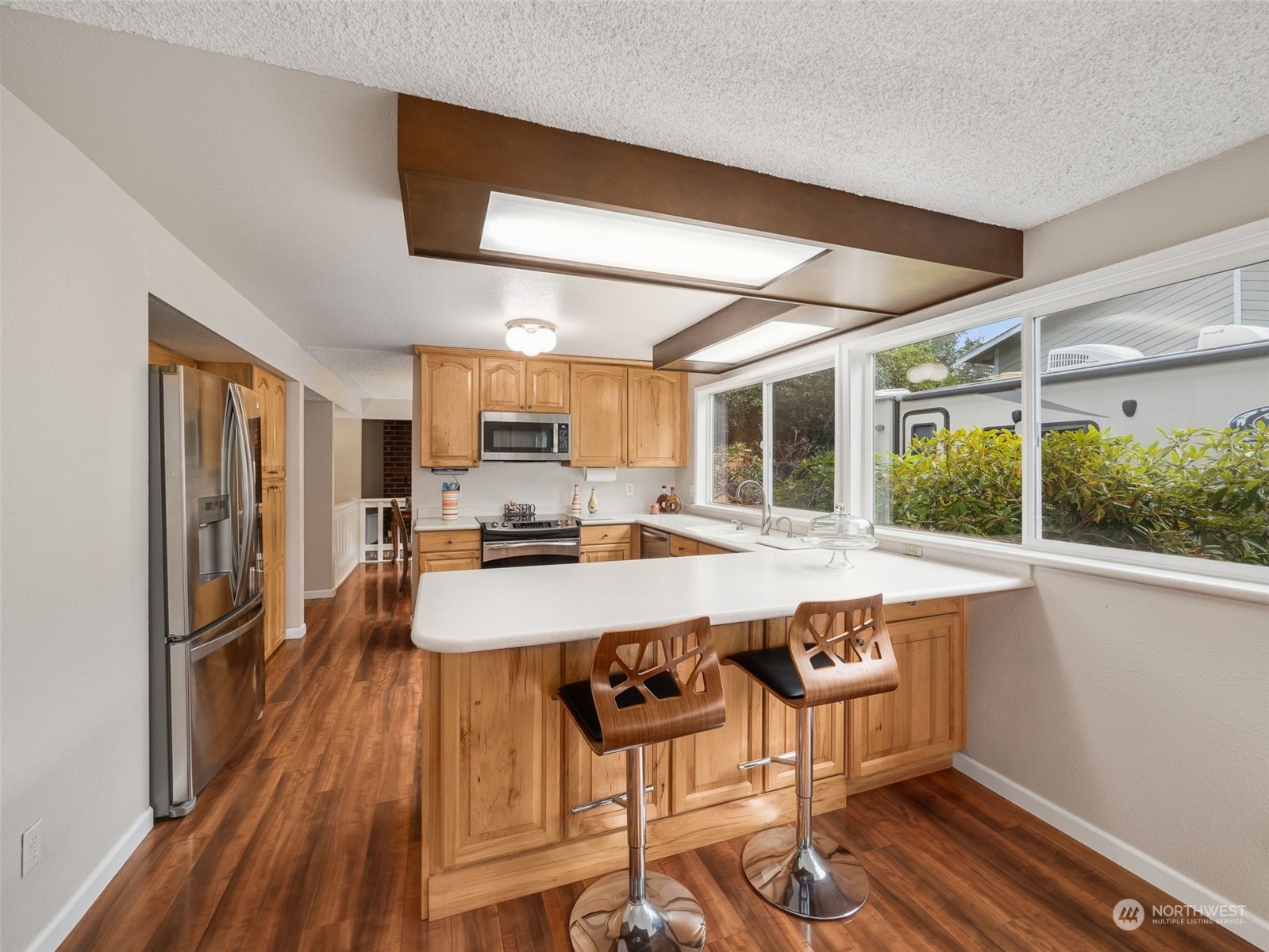 14130 148th Place Southeast Renton, WA 98059 - Photo 5 of 39 a large dining hall with stainless steel appliances granite countertop a stove and cabinets with wooden floor